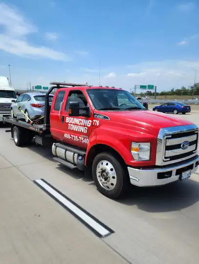 Bouncing Towing LLC flatbed tow truck on Texas highway