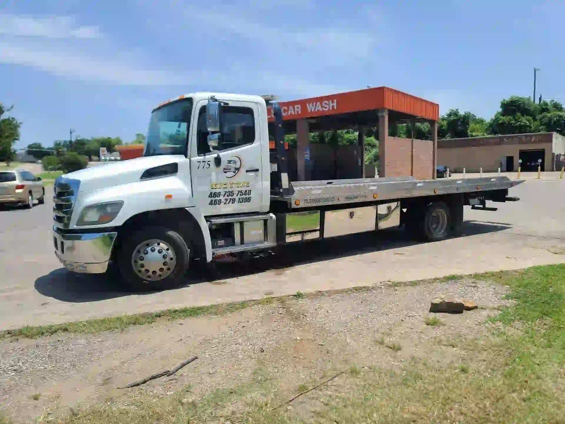 Bouncing Towing white flatbed truck ready for service in Dallas Texas